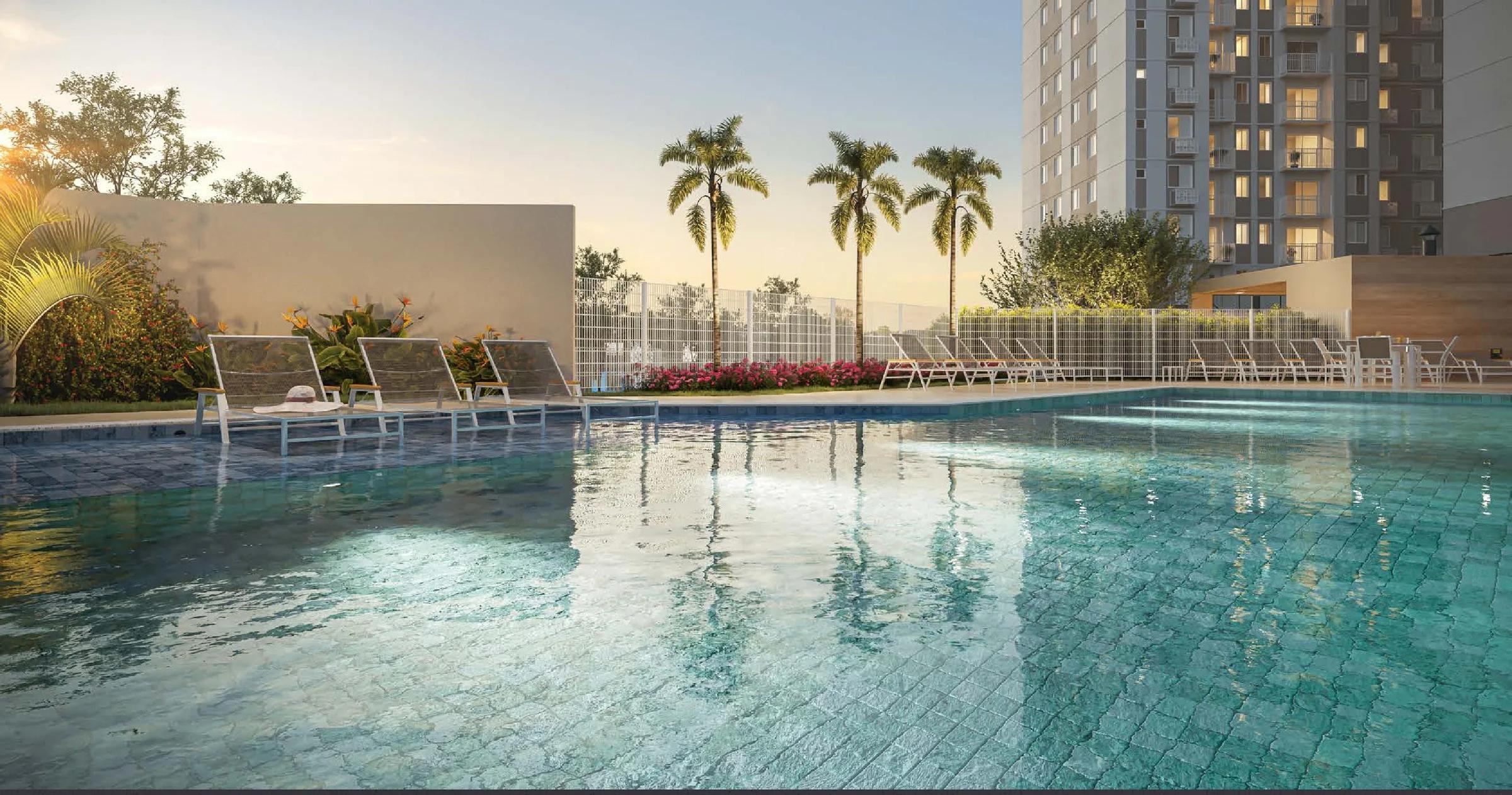 Piscina adulto com espreguiçadeiras, palmeiras e vista parcial da torre ao fundo