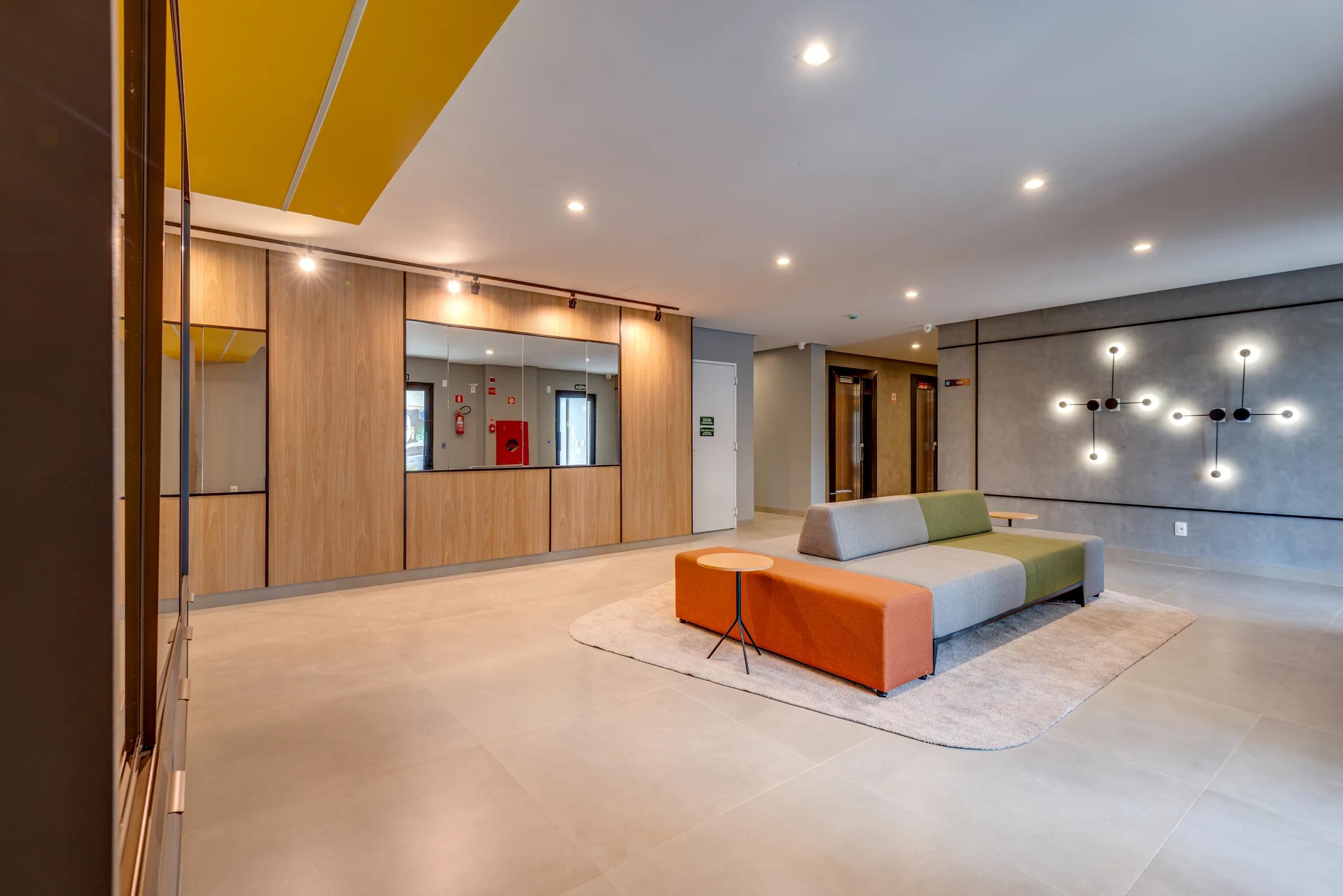 Lobby com sofás e painel de nichos