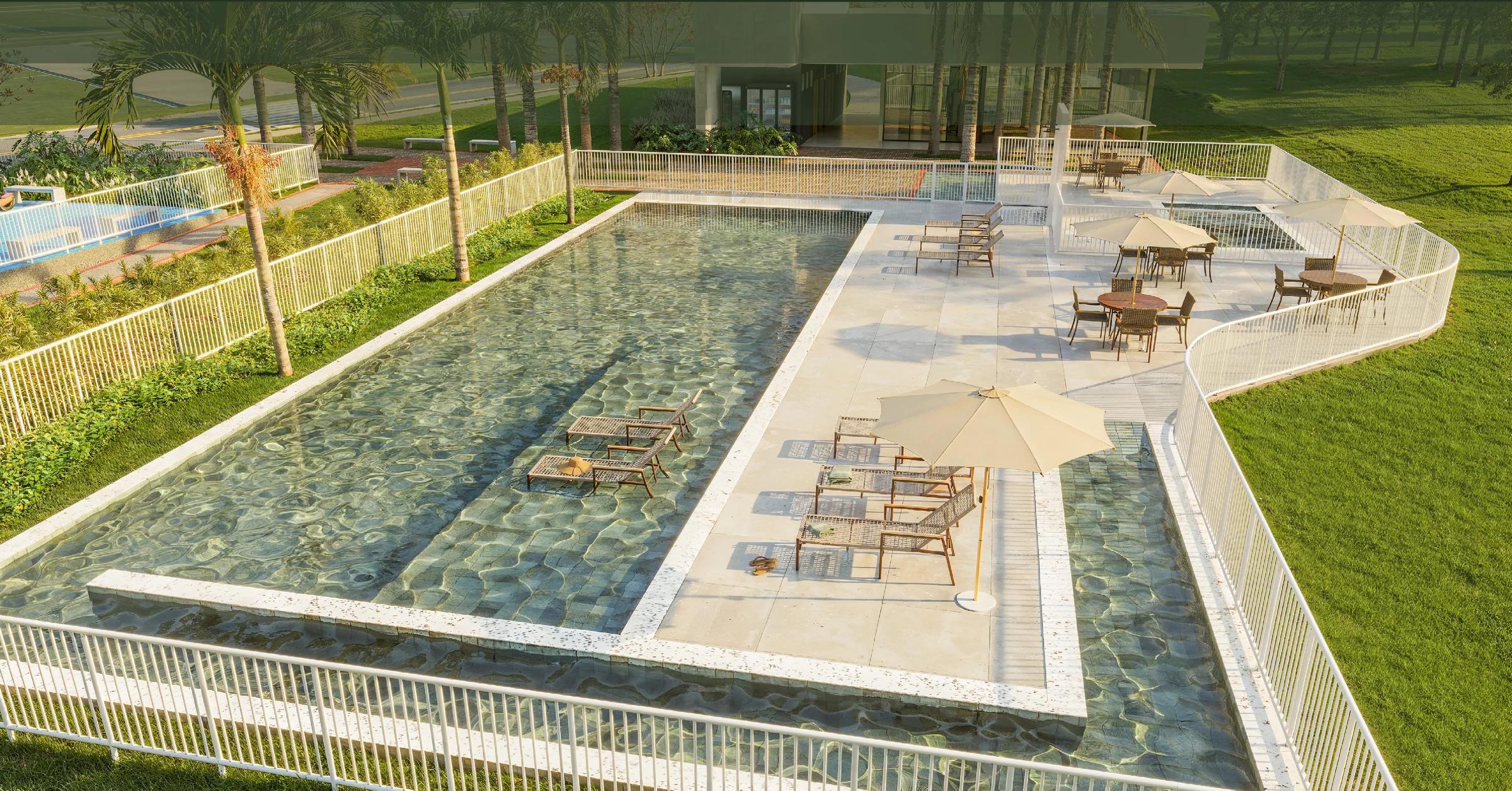 Piscina com raia, prainha com espreguiçadeiras e solário com mesas e ombrelones