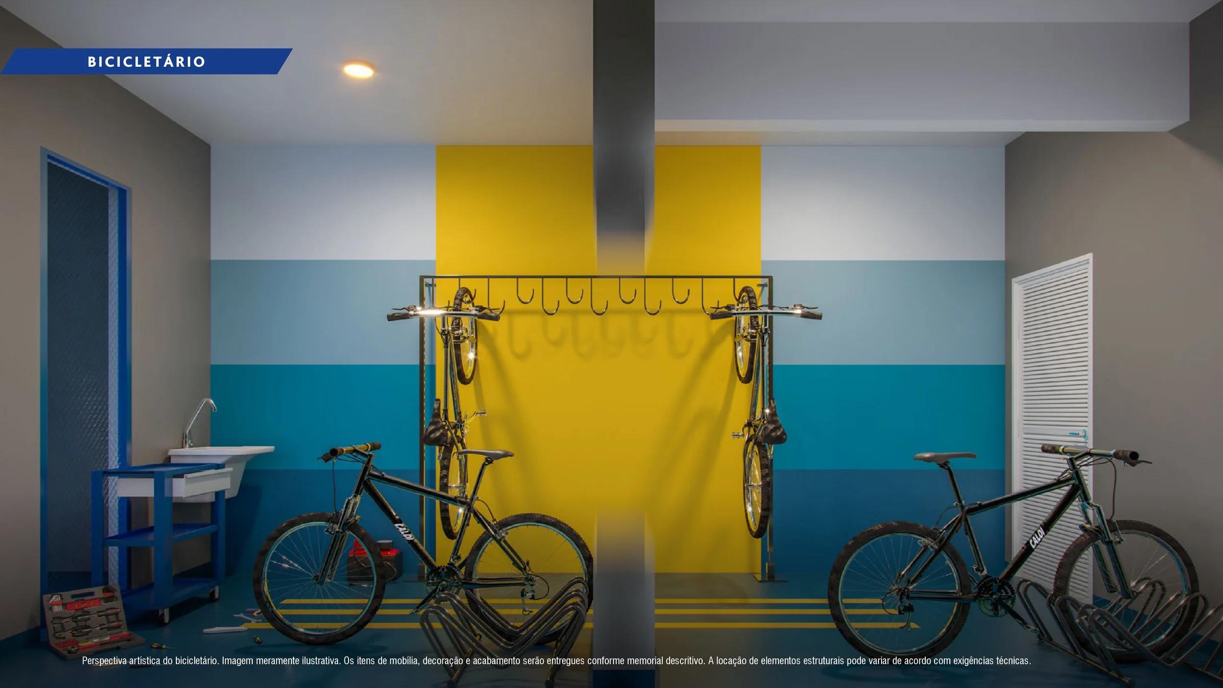 Bicicletário equipado com ganchos suspensos de parede, bancada e bicicletas.