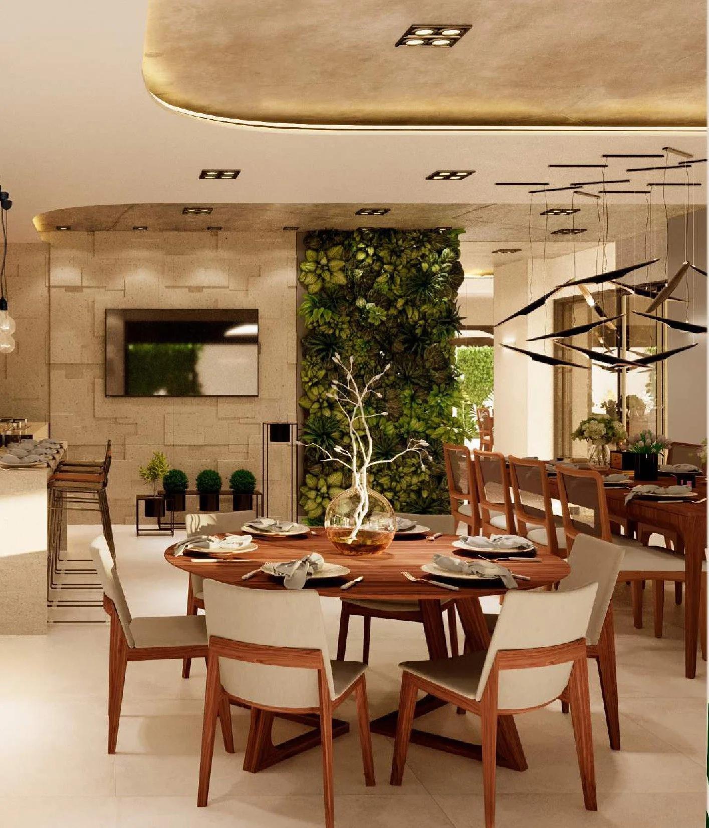 Espaço gourmet e salão de festas decorado com mesa redonda e jardim vertical