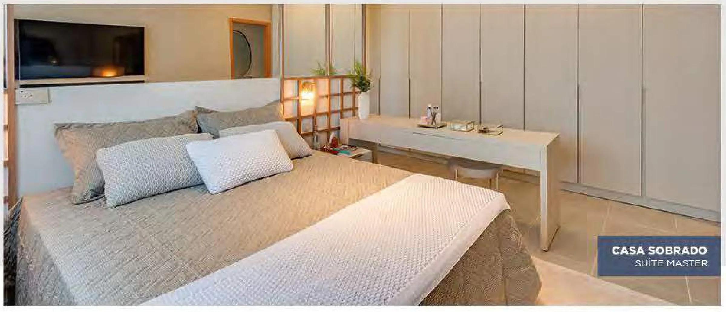 Suíte master do sobrado decorado com cama de casal e bancada de trabalho