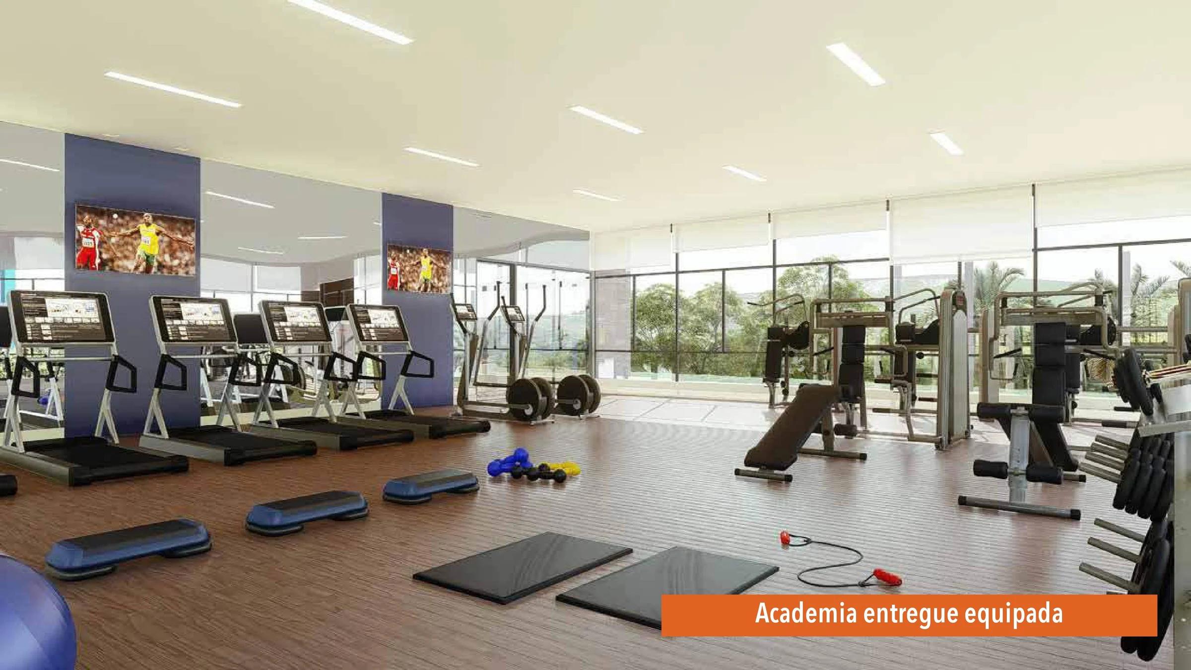 Academia equipada com esteiras, aparelhos de musculação e vista para o verde