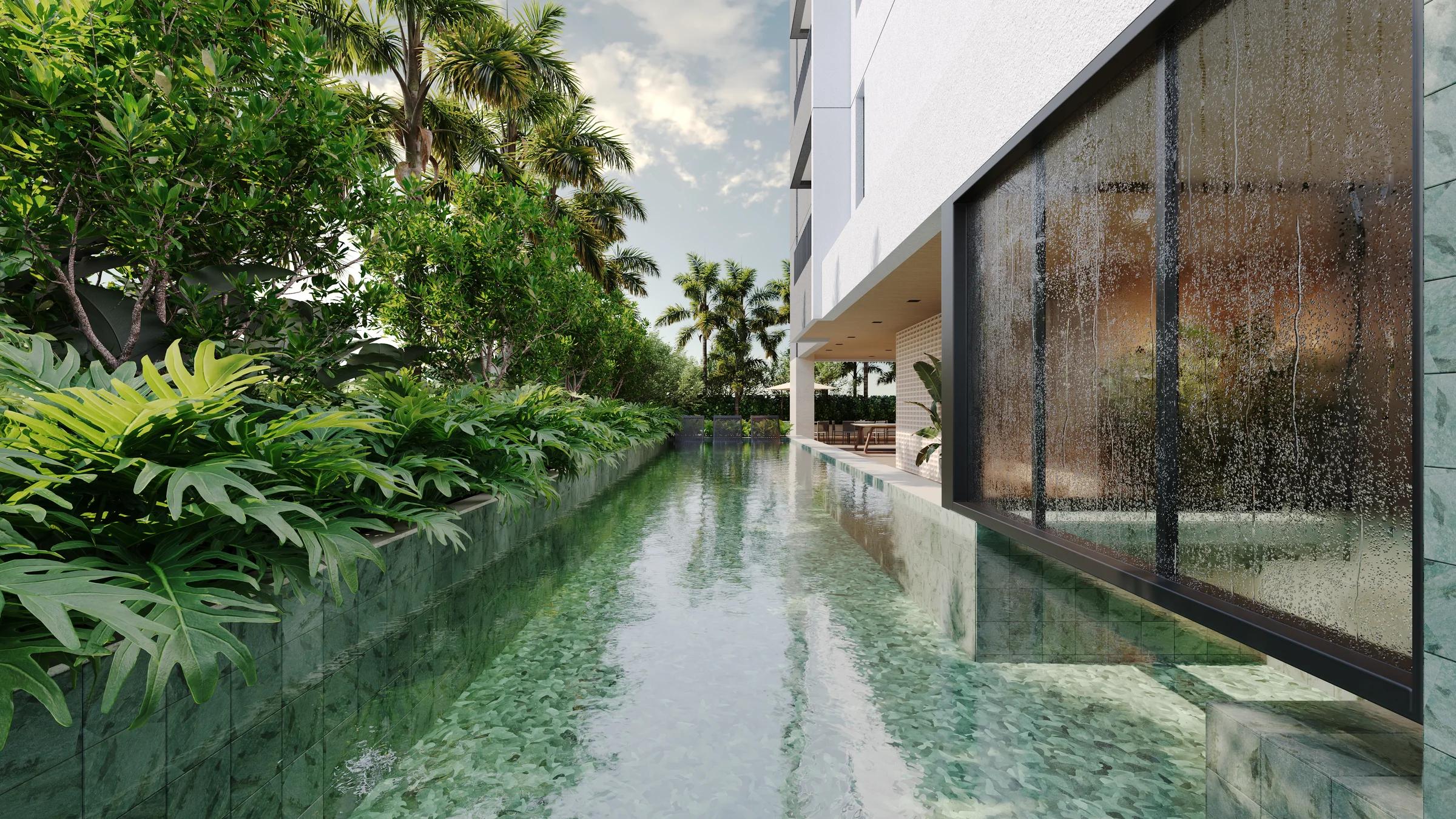 Piscina com raia cercada por vegetação tropical e cascata de vidro