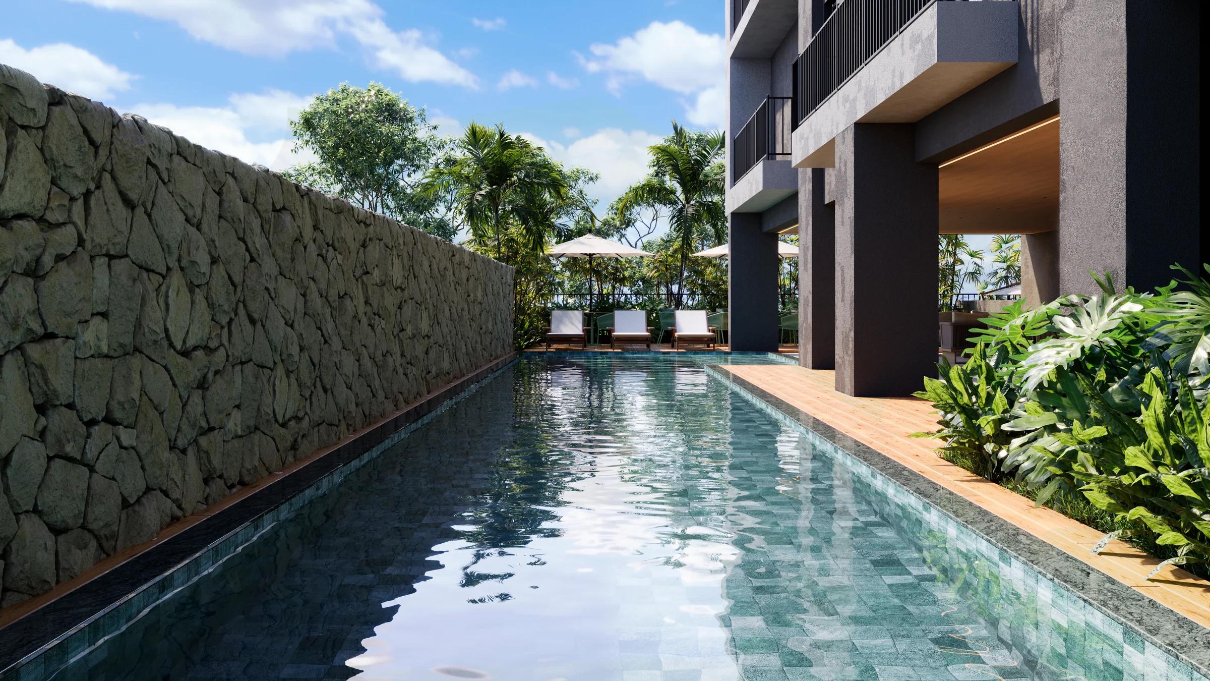 Piscina com raia de 20 metros, deck com espreguiçadeiras e muro de pedra