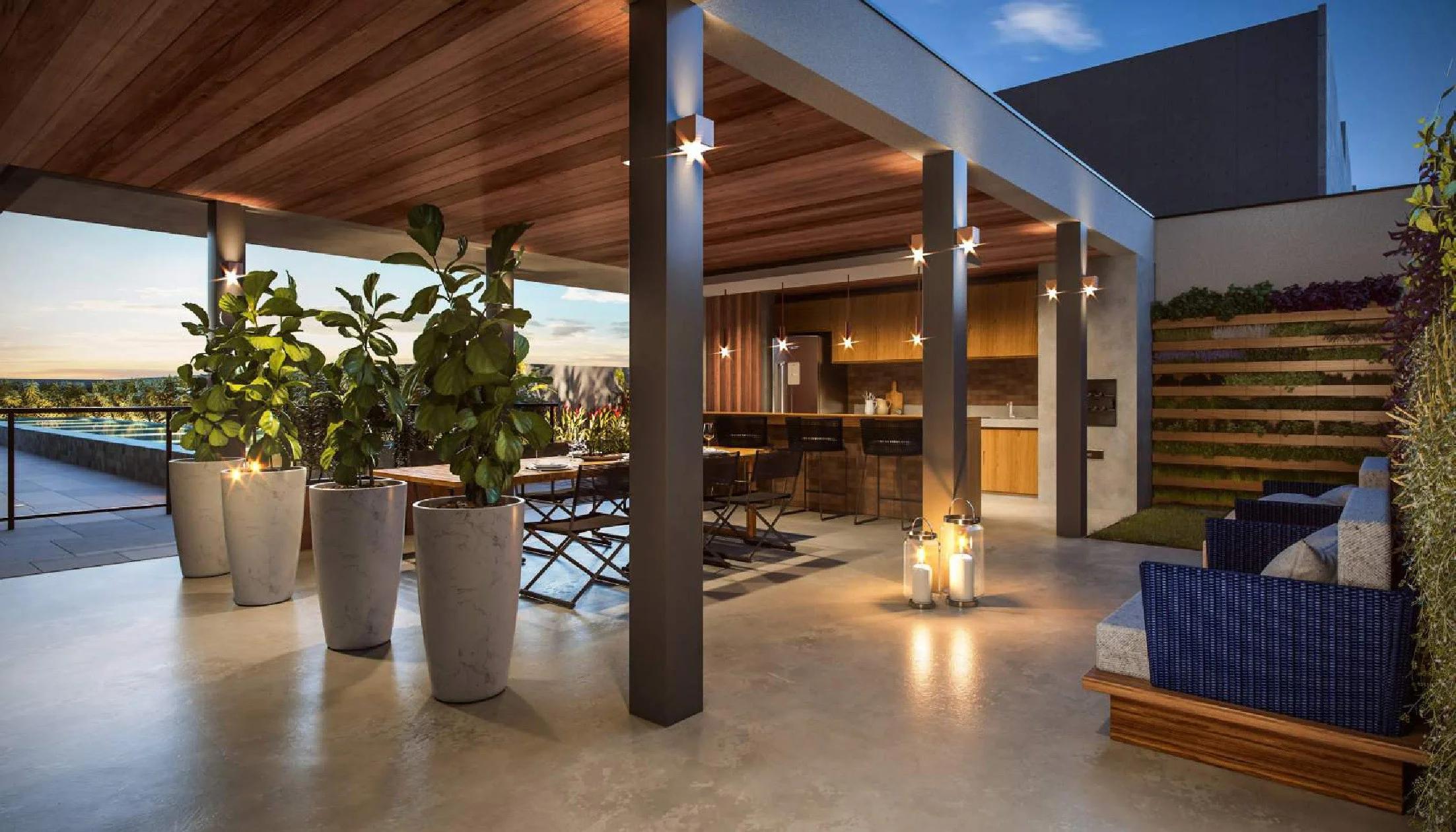 Espaço gourmet ao ar livre sob pergolado, com churrasqueira, mesas e lounge ao entardecer