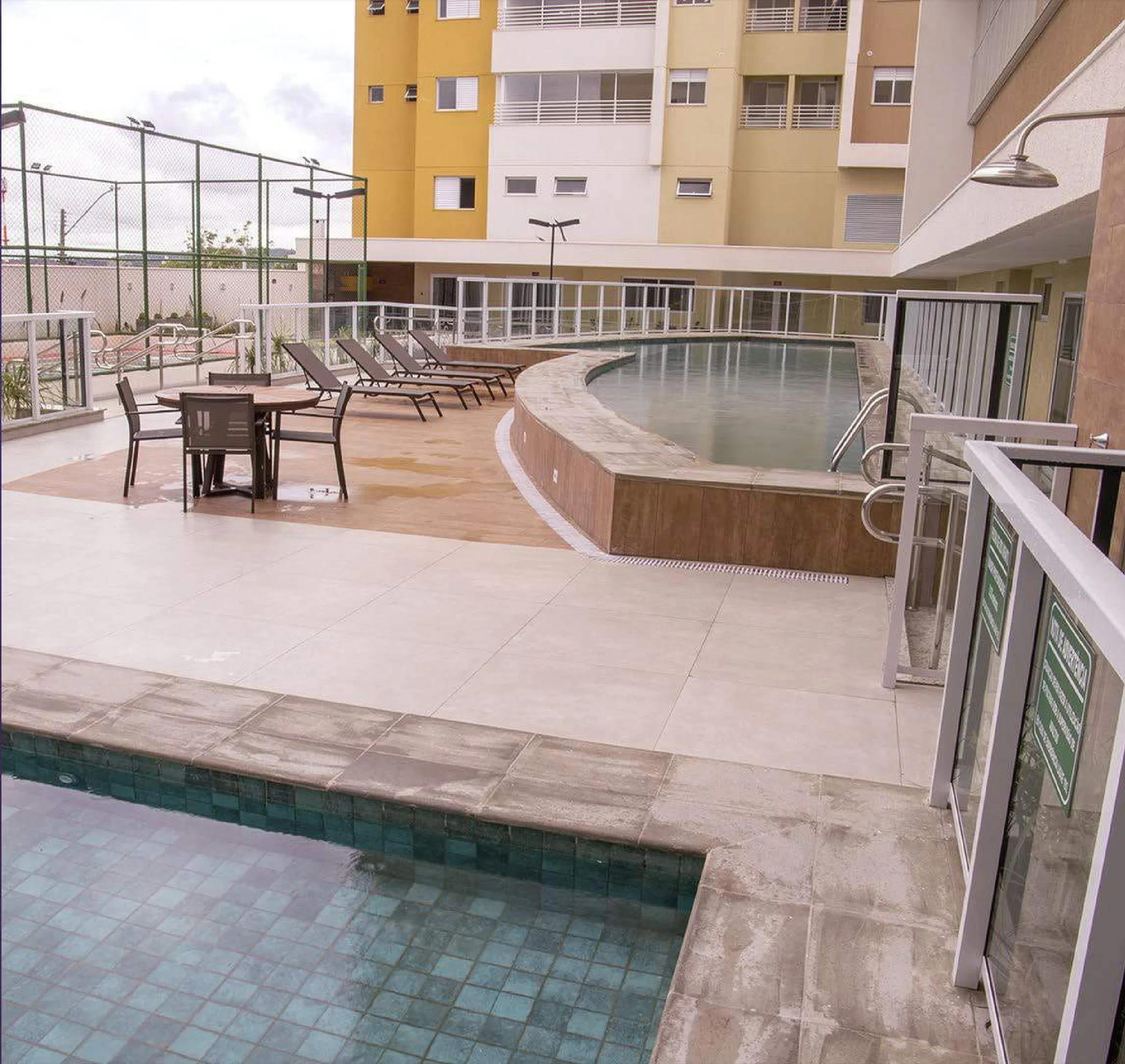 Piscina externa com solário, espreguiçadeiras e conjunto de mesa com cadeiras