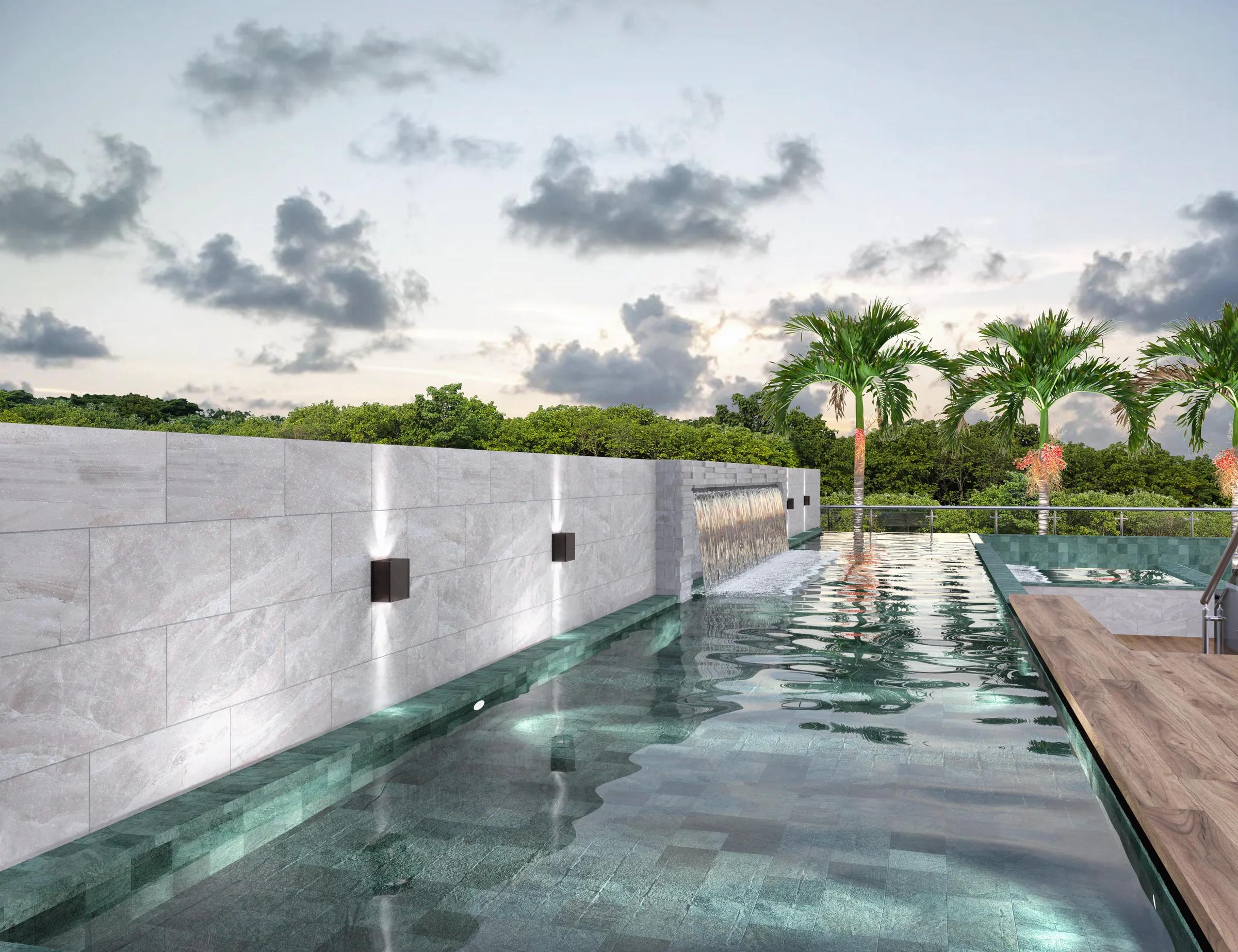 Piscina adulto com cascata, espreguiçadeiras e guarda-sol