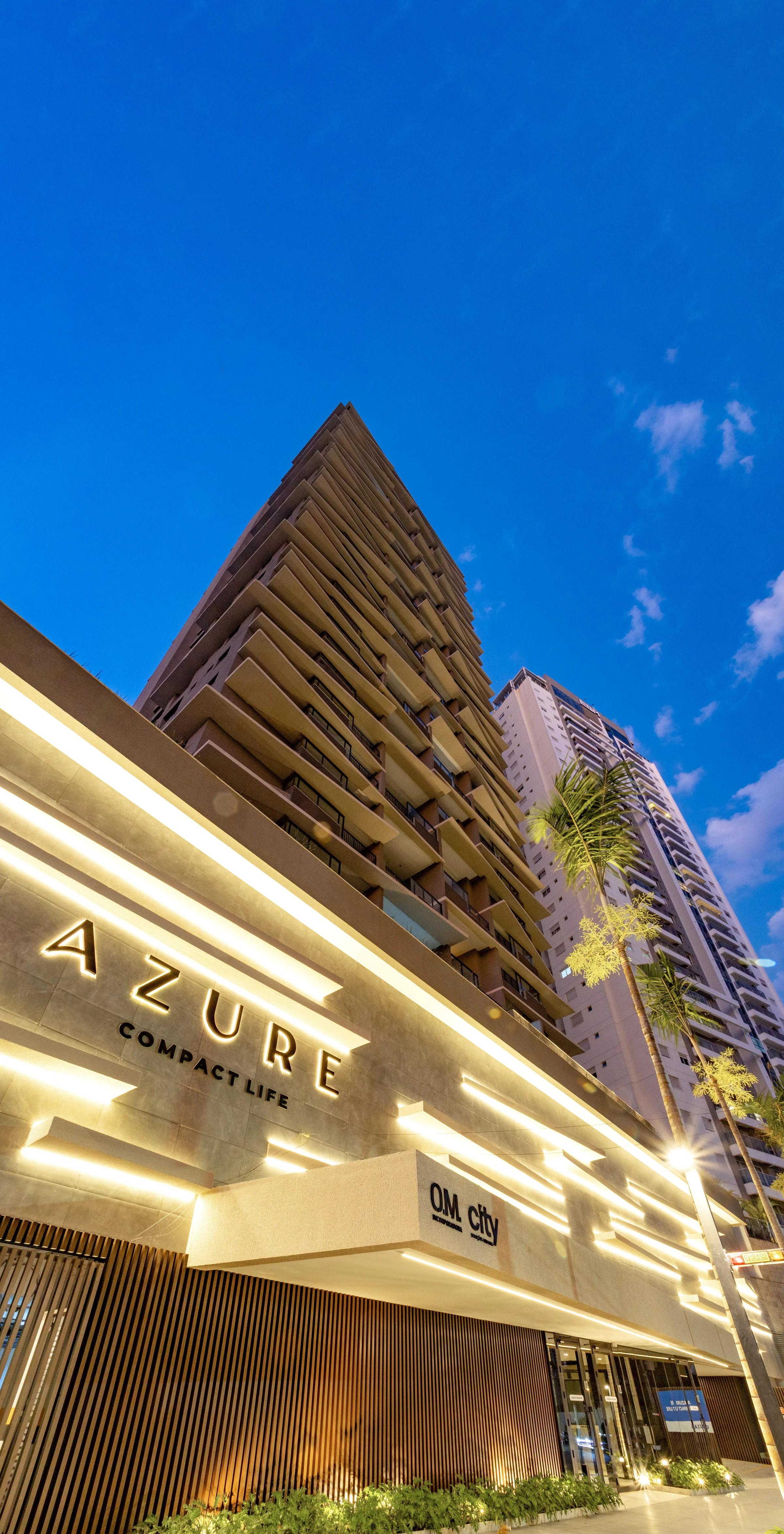 Fachada da torre ao entardecer com entrada iluminada e céu azul