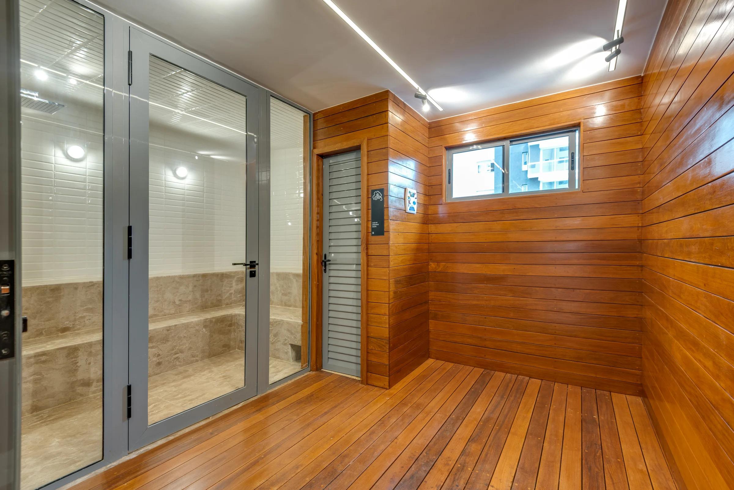 Foto da cabine de elevadores e do revestimento de madeira no hall.