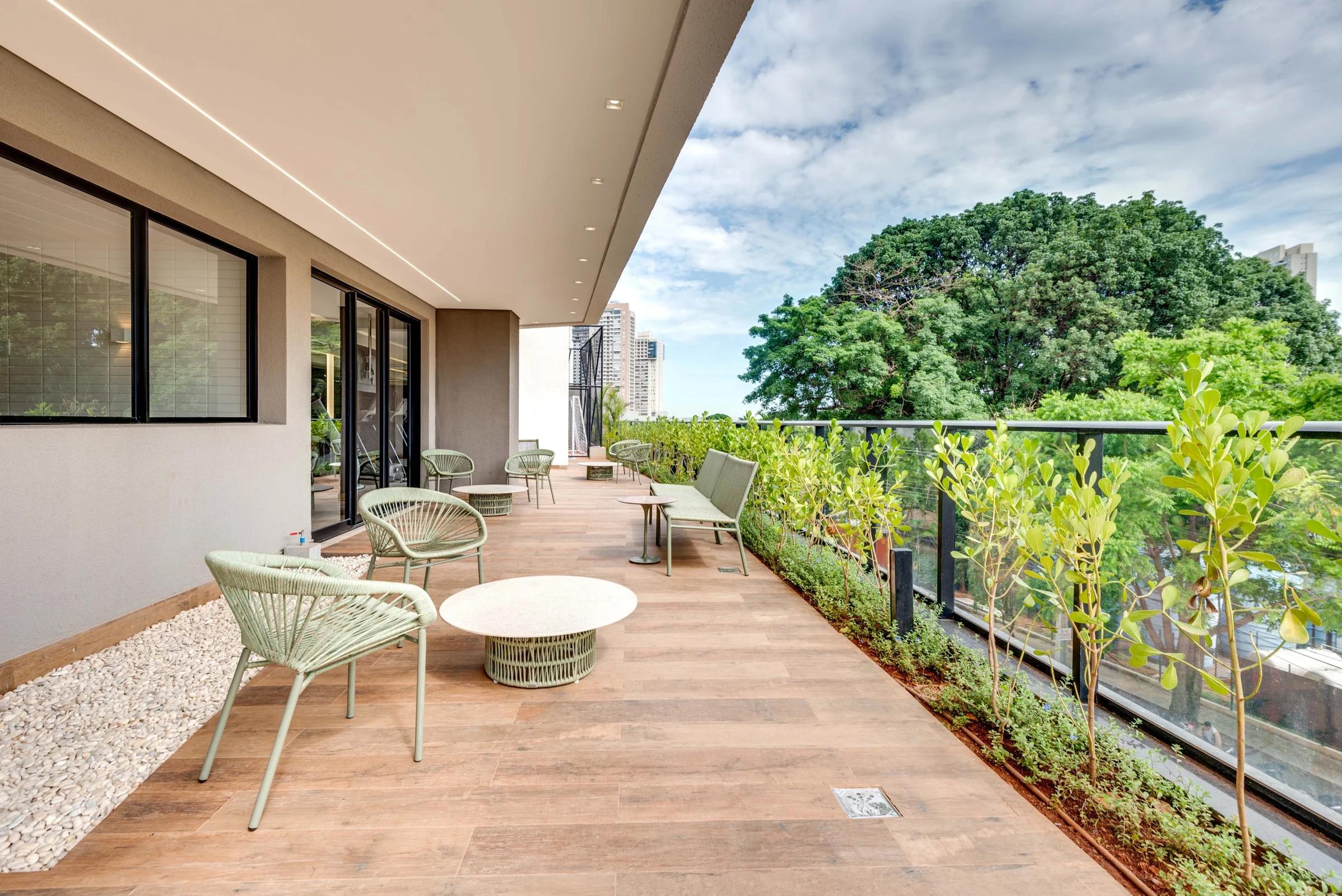 Foto do terraço com mesas, cadeiras e vegetação