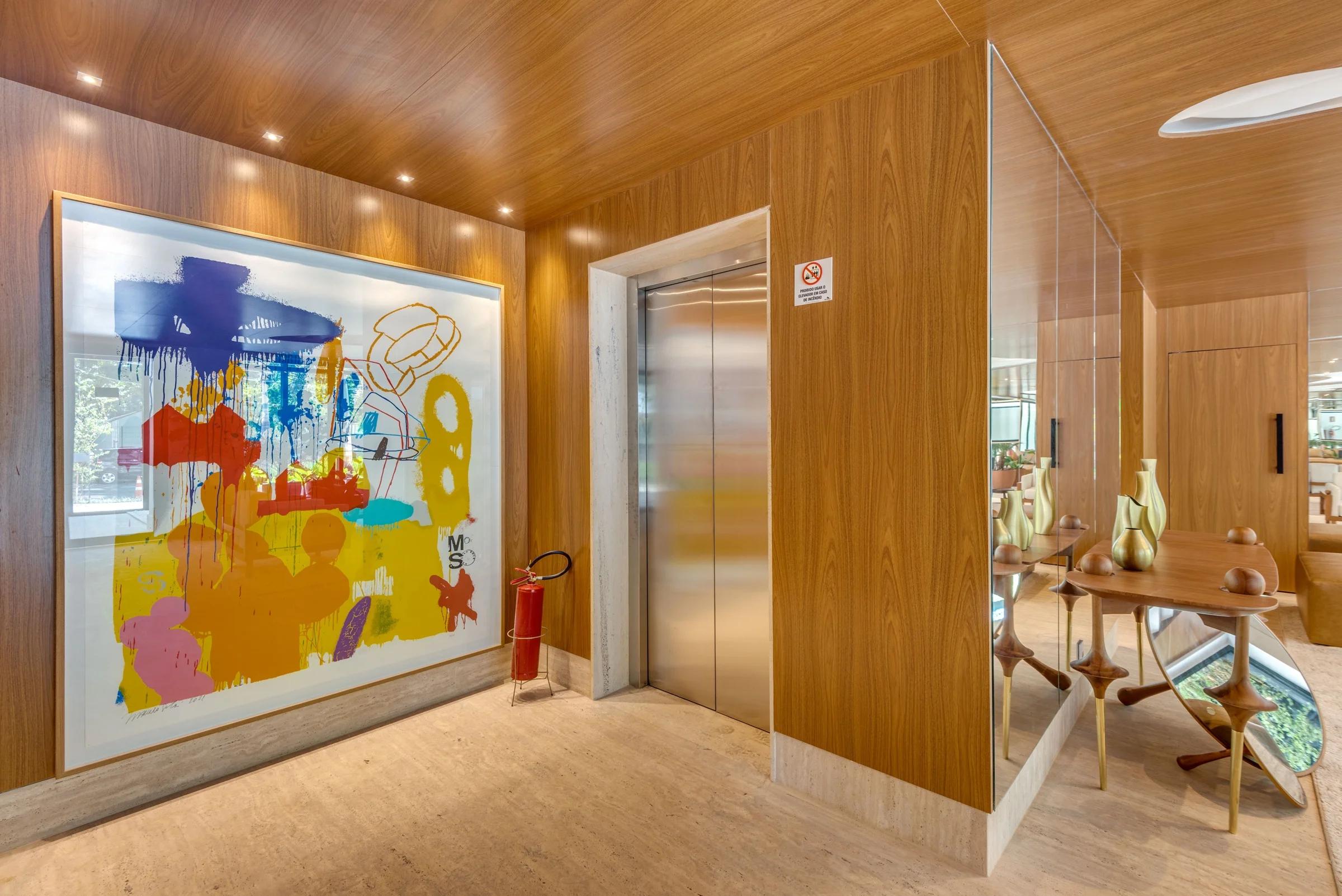 Foto do hall com elevador e obra de arte