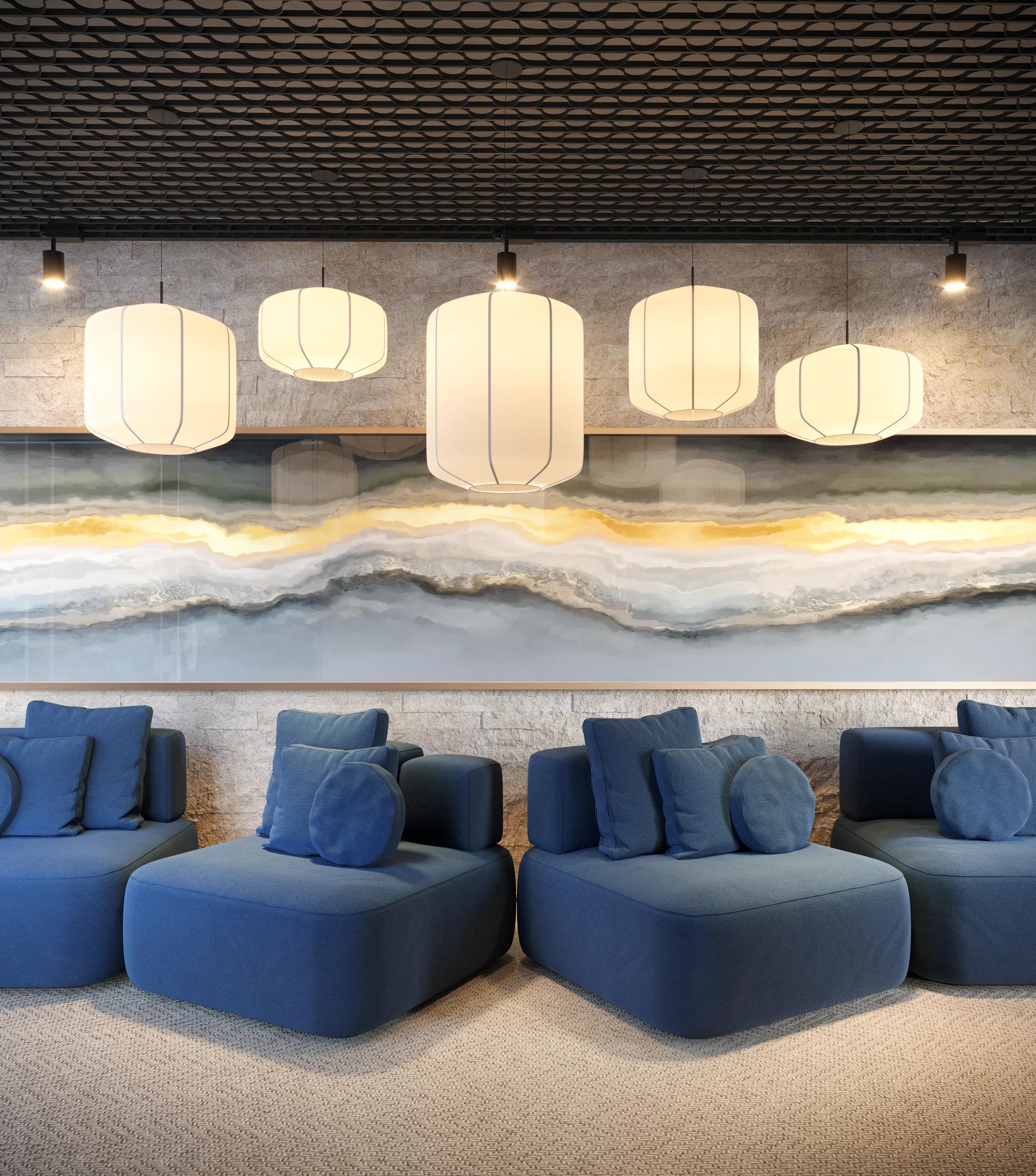 Lobby de entrada com sofás modulares azuis, luminárias pendentes e parede em pedra rústica