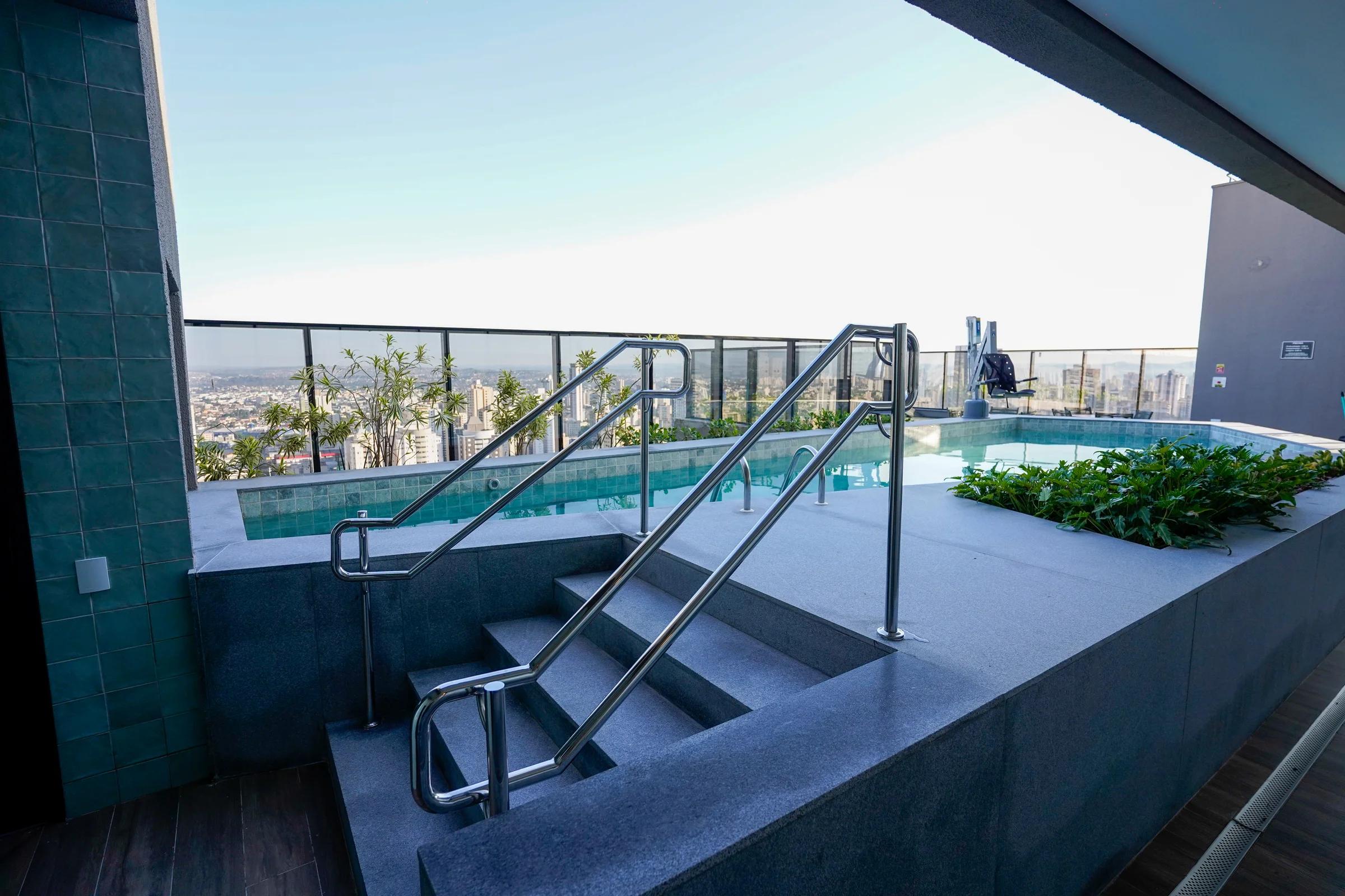 Foto da piscina na cobertura e da área de descanso.