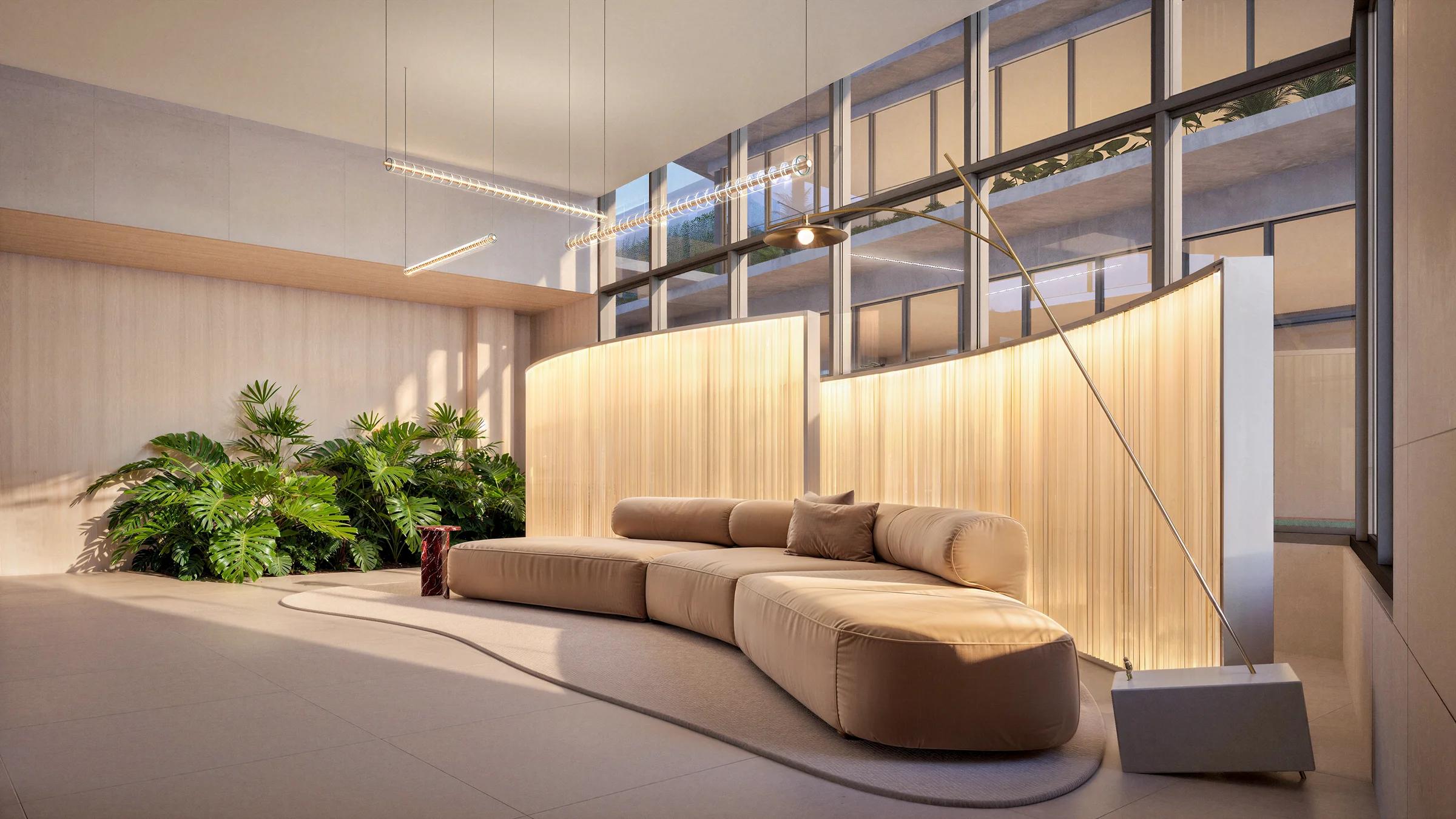 Lobby com sofá, jardim interno e estrutura envidraçada.