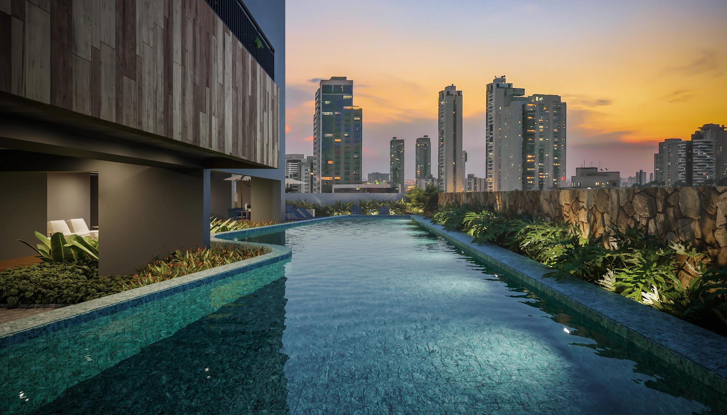 Piscina em formato orgânico com raia e vegetação no entorno ao entardecer