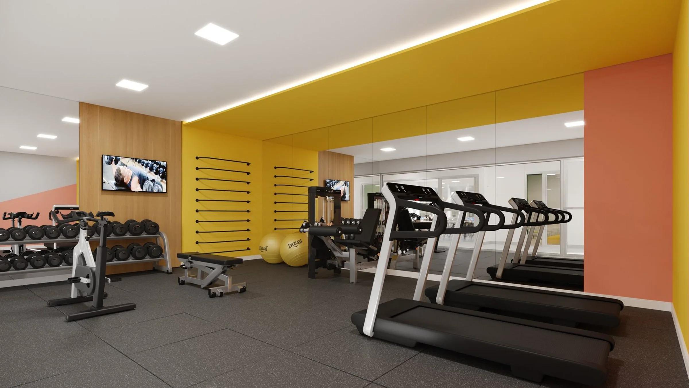 Academia equipada com esteiras, bicicleta ergométrica e espaço para musculação